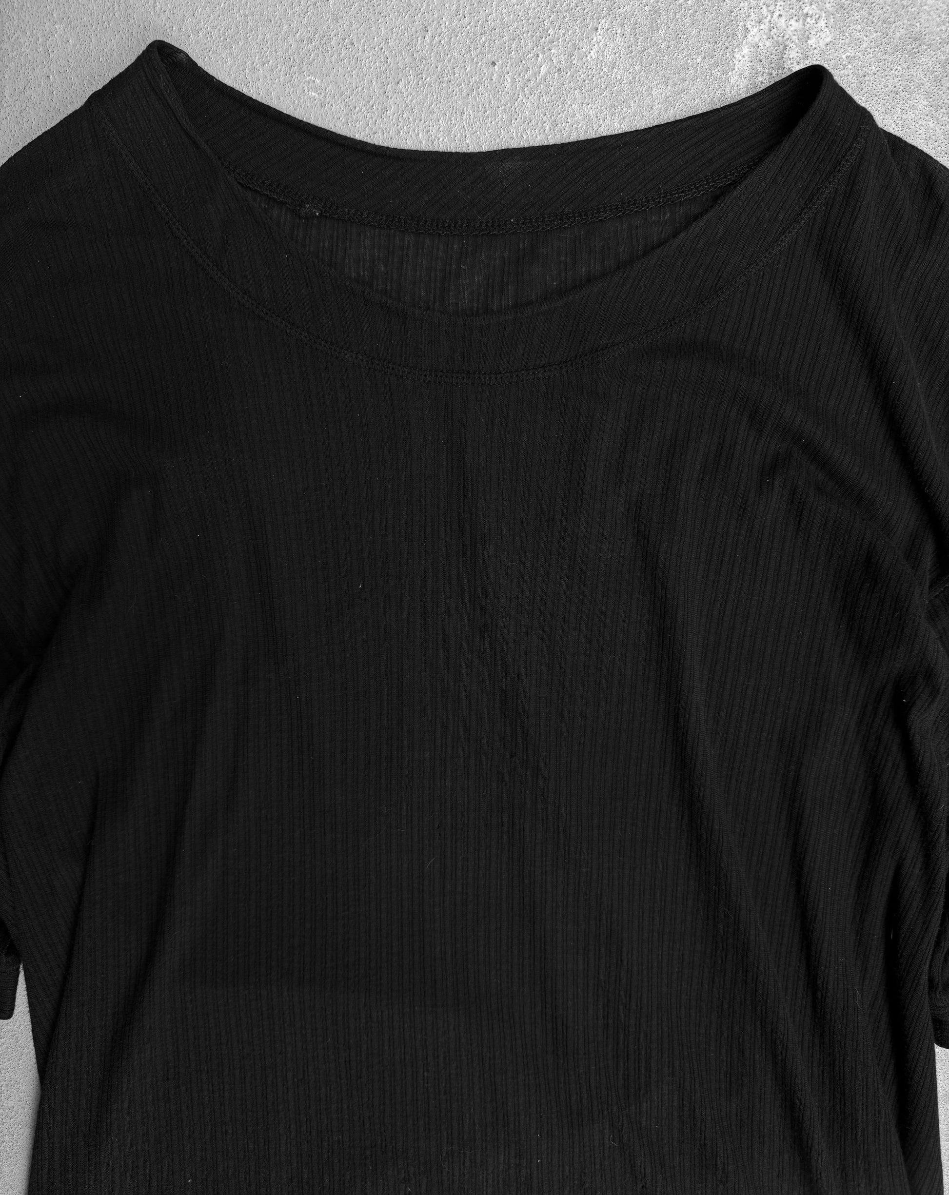 A DRIEW Boris Bidjan Saberi SS15 ‘TS2-F0407’ black ribbed raglan T-shirt, size M, short-sleeved and oversized, is laid flat on a gray surface showing only its upper half.