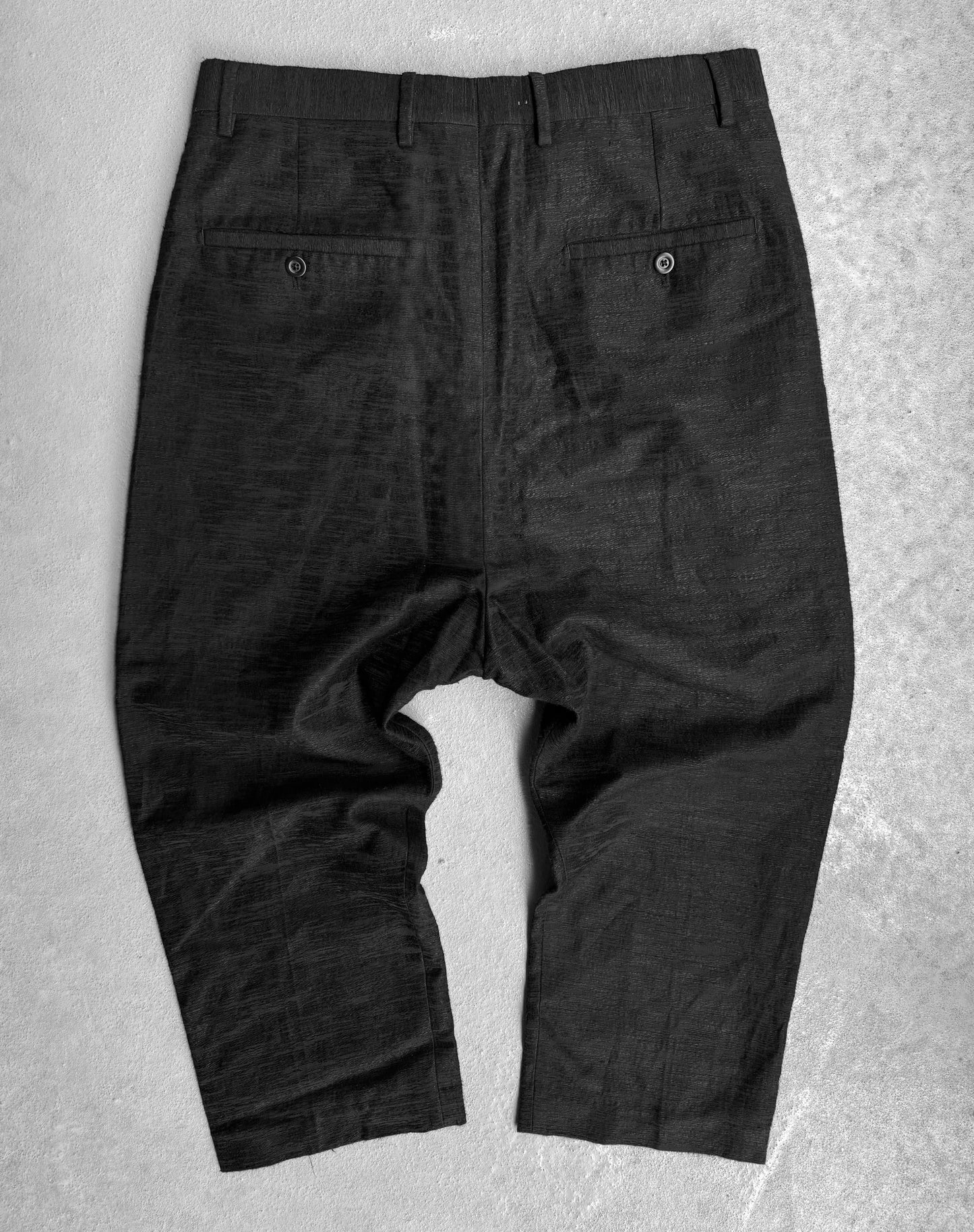 Rick Owens SS17 “WALRUS” Radiant woven cropped pants in black, IT 48/US 32-33, loose fit, shown from the back on a light textured surface with two buttoned back pockets.