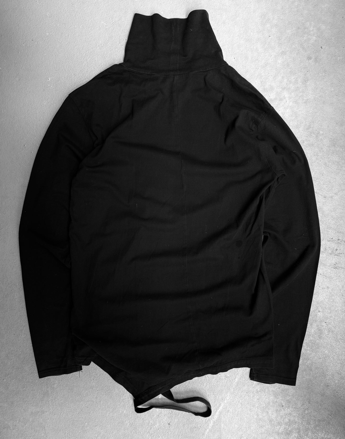 The Viridi-Anne Ninja High Neck Cotton Long-sleeves in black, size 2 (medium), features a high collar and two bottom straps. Laid flat on a light textured surface, minor fading is visible. Brand: The Viridi-Anne.