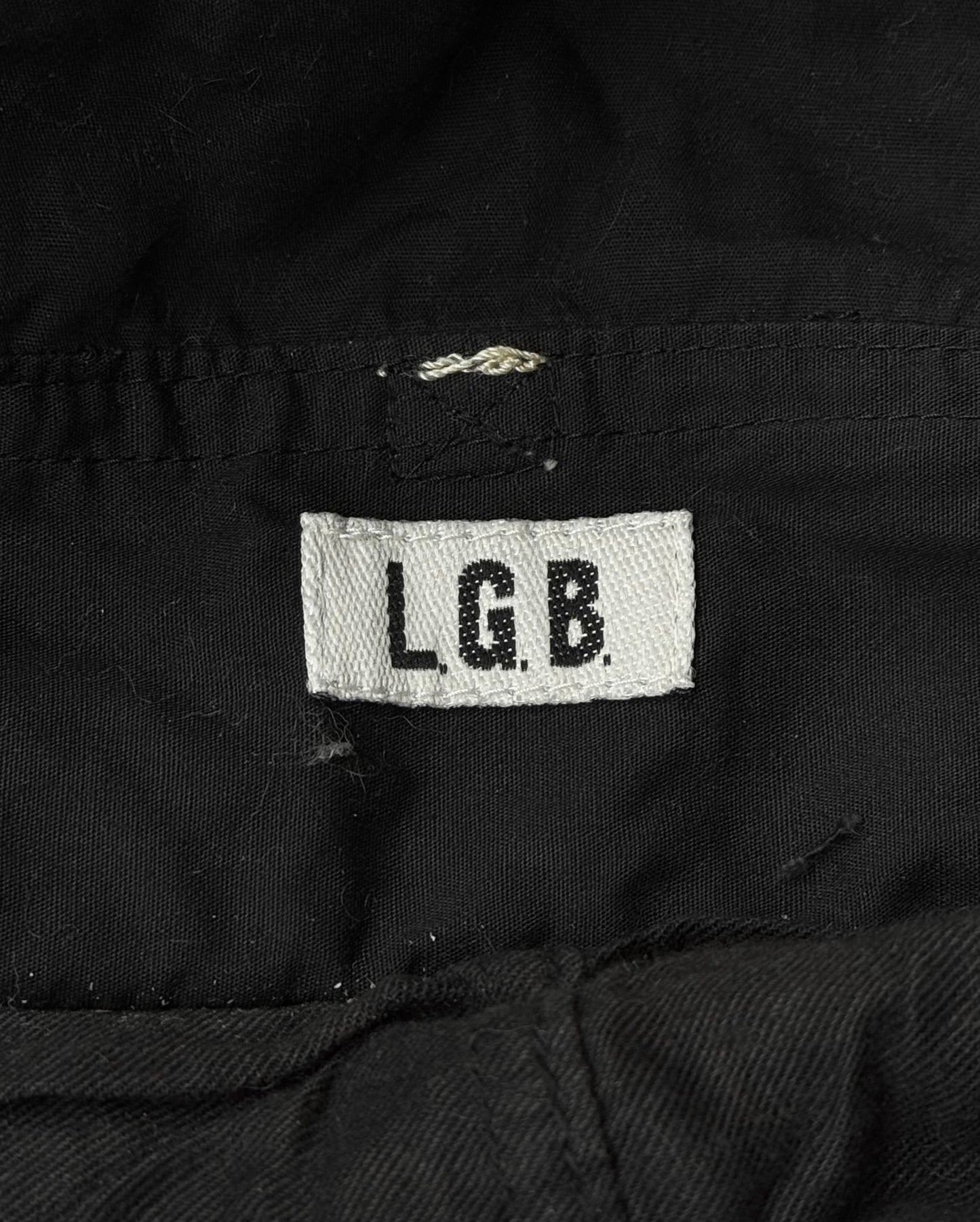 The L.G.B Early 00s Pilot Cargo Capris by L.G.B feature a white fabric tag with black L.G.B. lettering sewn onto black material and repair patches that add extra character.