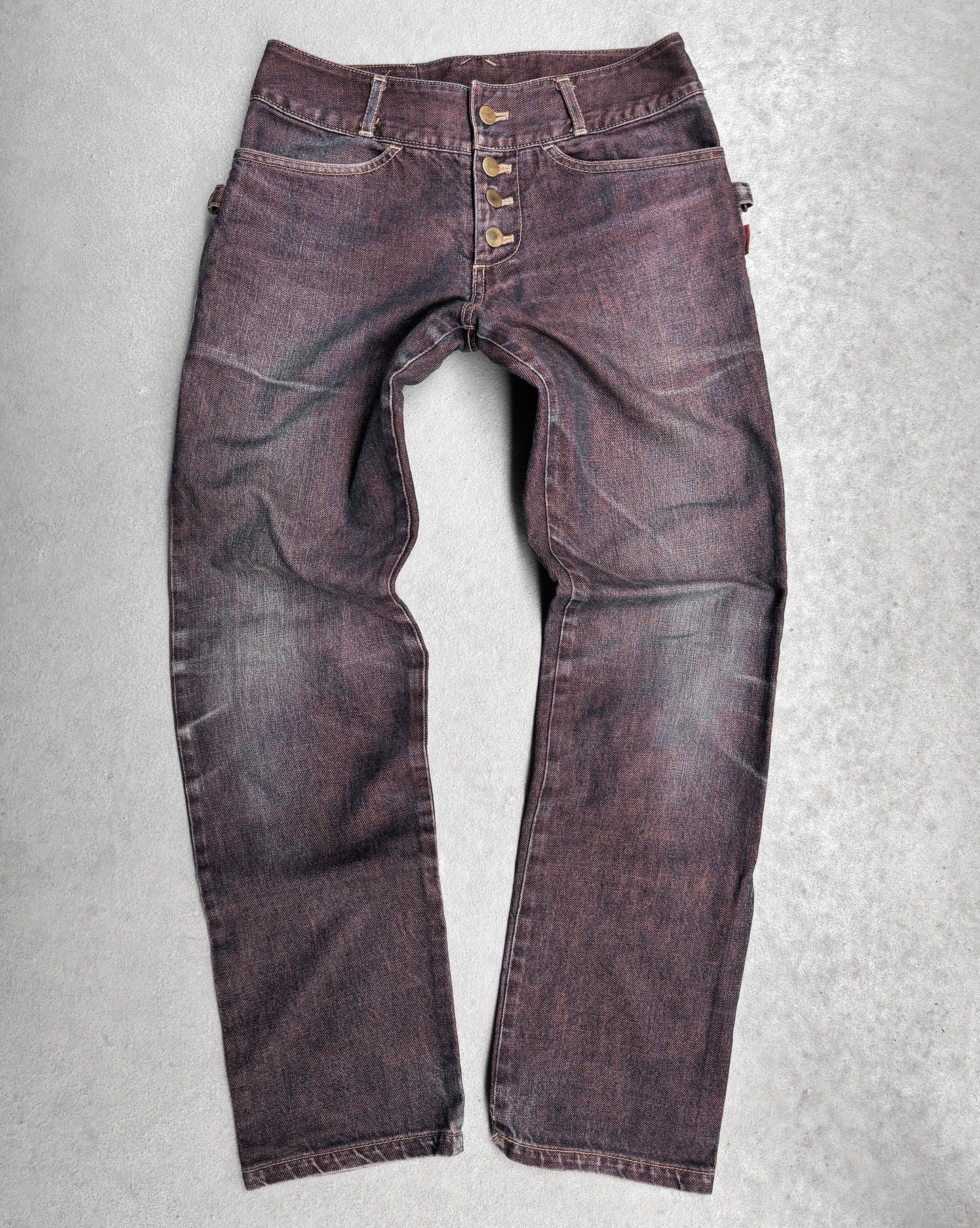 The Beauty:Beast Late 90s Over-dyed Articulate Bootcut Denim jeans, laid flat on a light gray surface, channel Tokyo fashion with an avant-garde, worn design featuring subtle creasing and distressing near the pockets and knees.