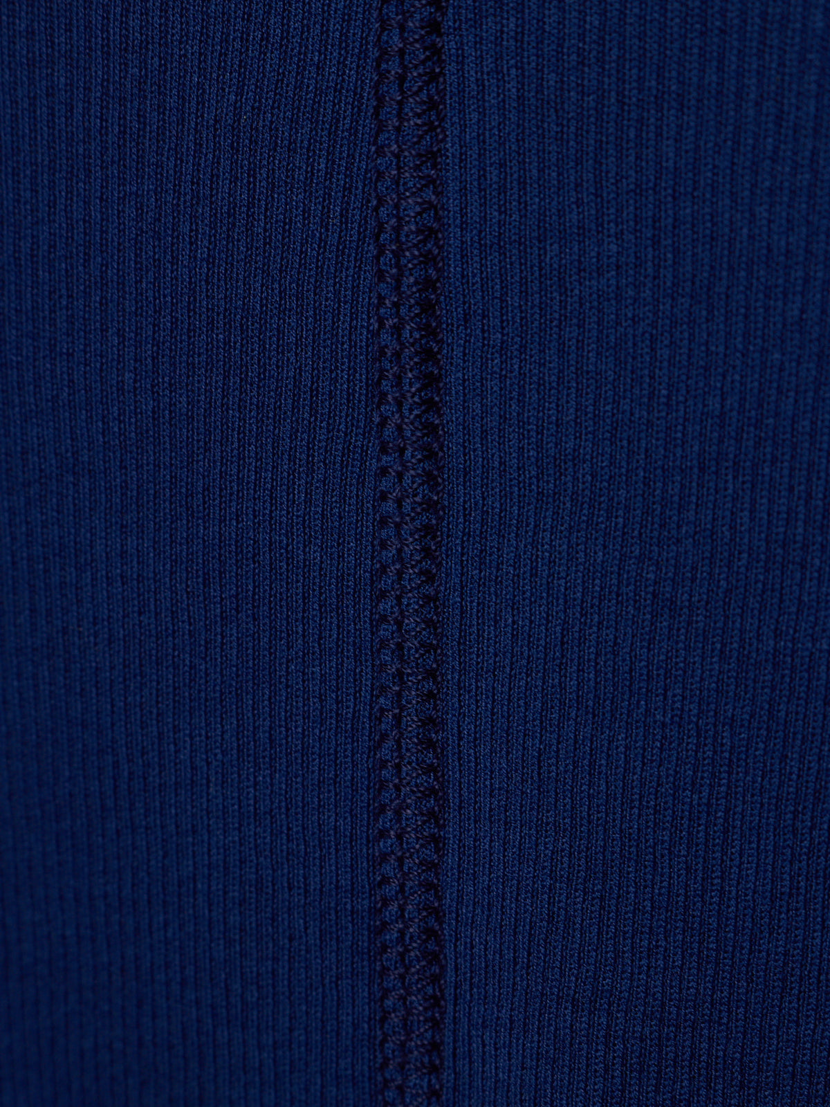 Close-up of a dark blue ribbed knit fabric with a vertical seam running down the center.