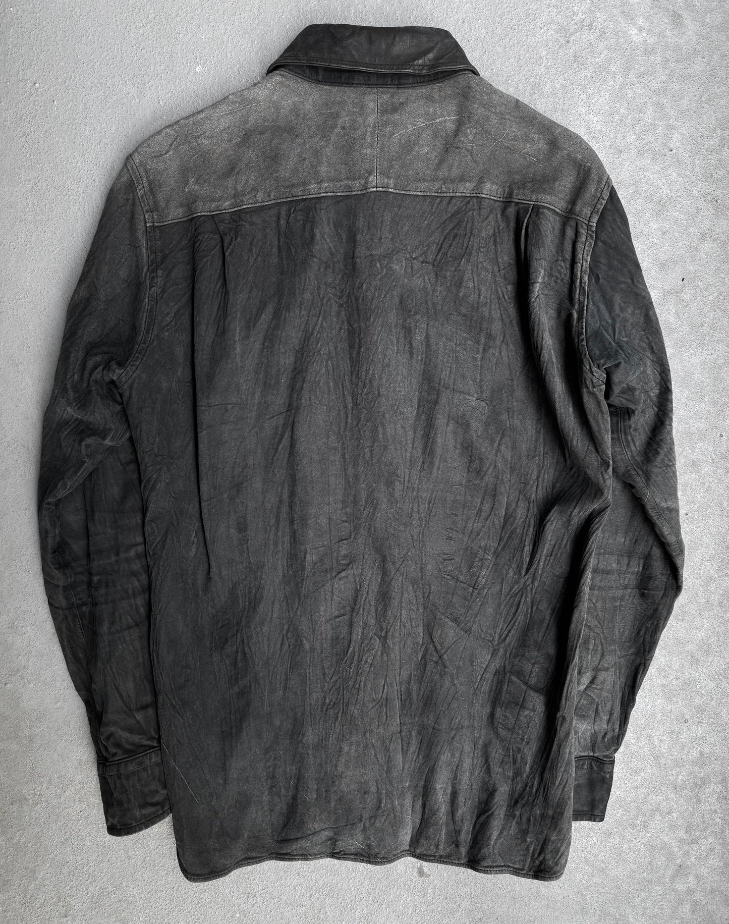 The Kyoji Maruyama Early 00s Washable Wrinkle Nubuck Leather Shirt features a weathered black finish with creases and faded areas, laid flat to display the back—reflecting minimalist Japanese design.