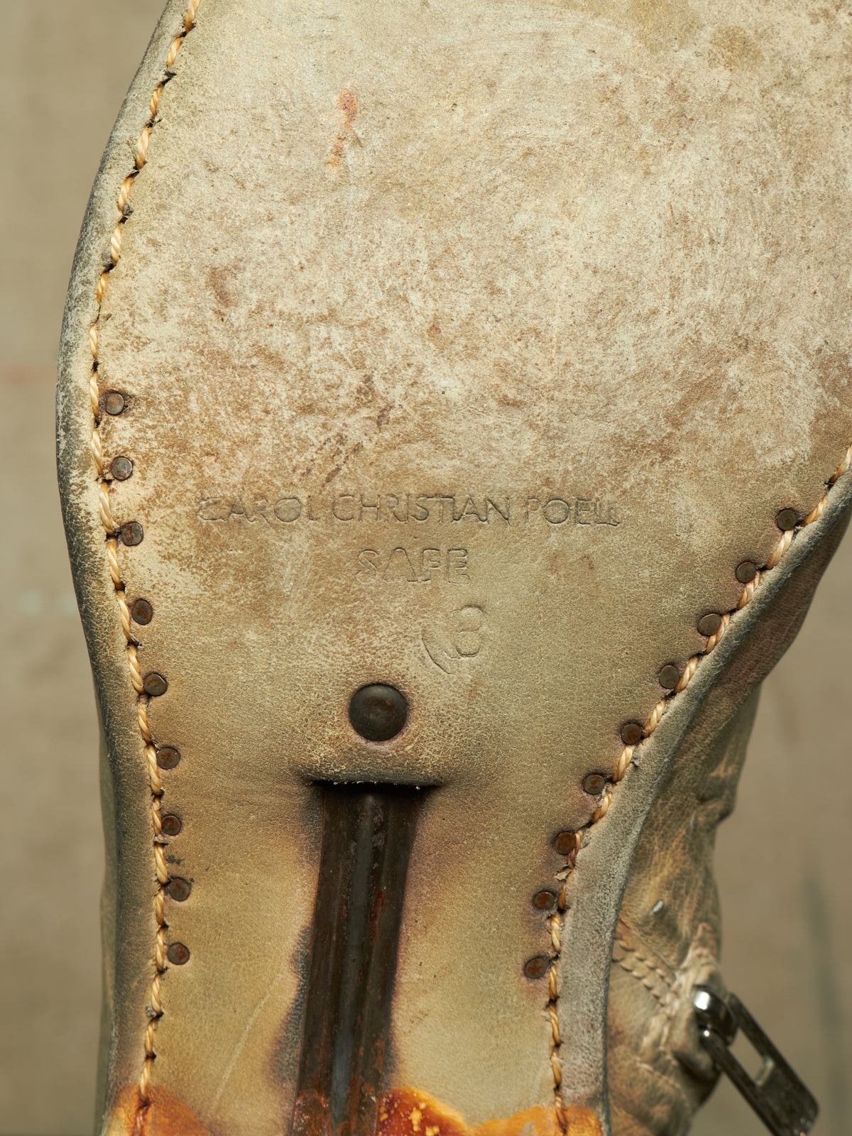 Close-up of the sole of a worn leather boot, showing the brand name Karl Christian Faber stamped in the center, with visible stitching, a pull tab, and a distressed tan-to-brown color.