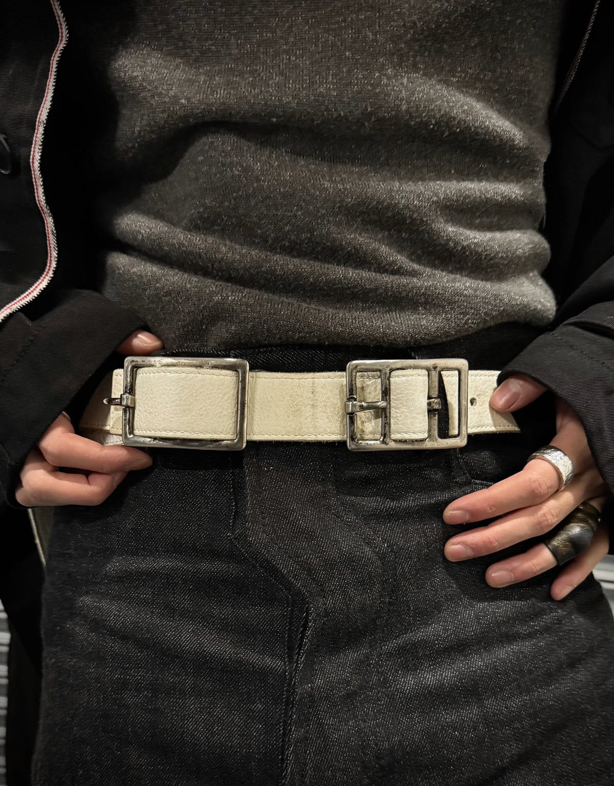 Person wearing a belt with a large buckle, focusing on the waist area.
