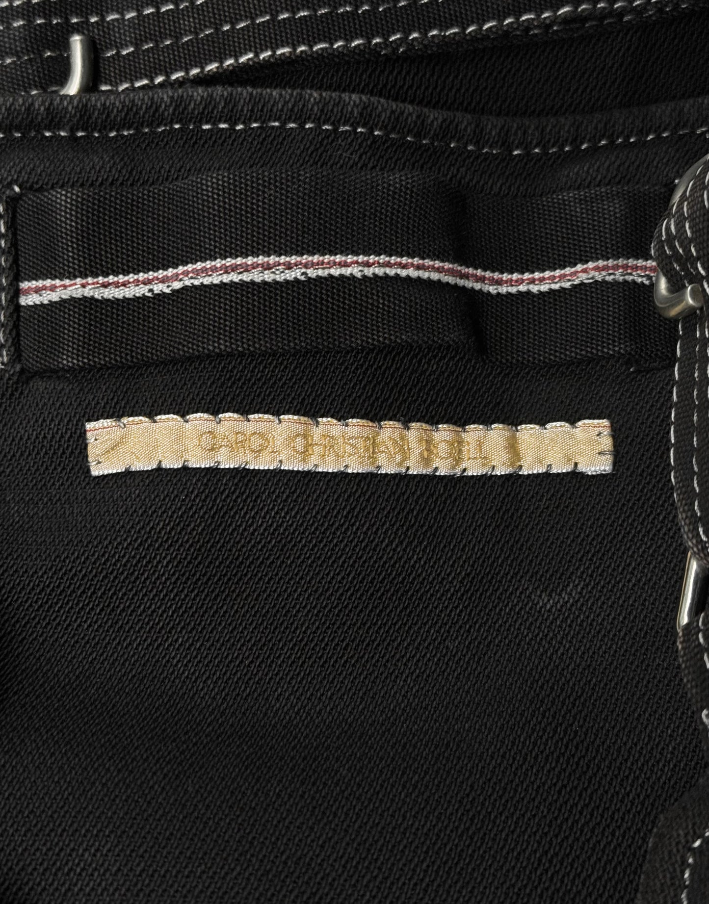 Close-up of a black denim fabric with a brand label.