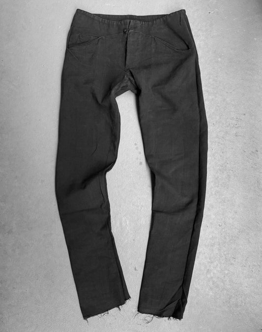 The m.a+ by Maurizio Amadei ‘P211’ 5-Pockets Straight Leg Pants in a dark shade feature frayed hems, front pockets, and a button closure, showcasing Italian craftsmanship with their distinct, slightly wrinkled texture.