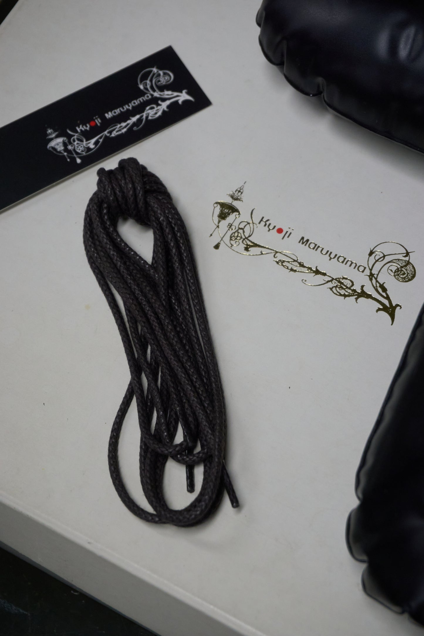 Black rope on a white surface with branding visible