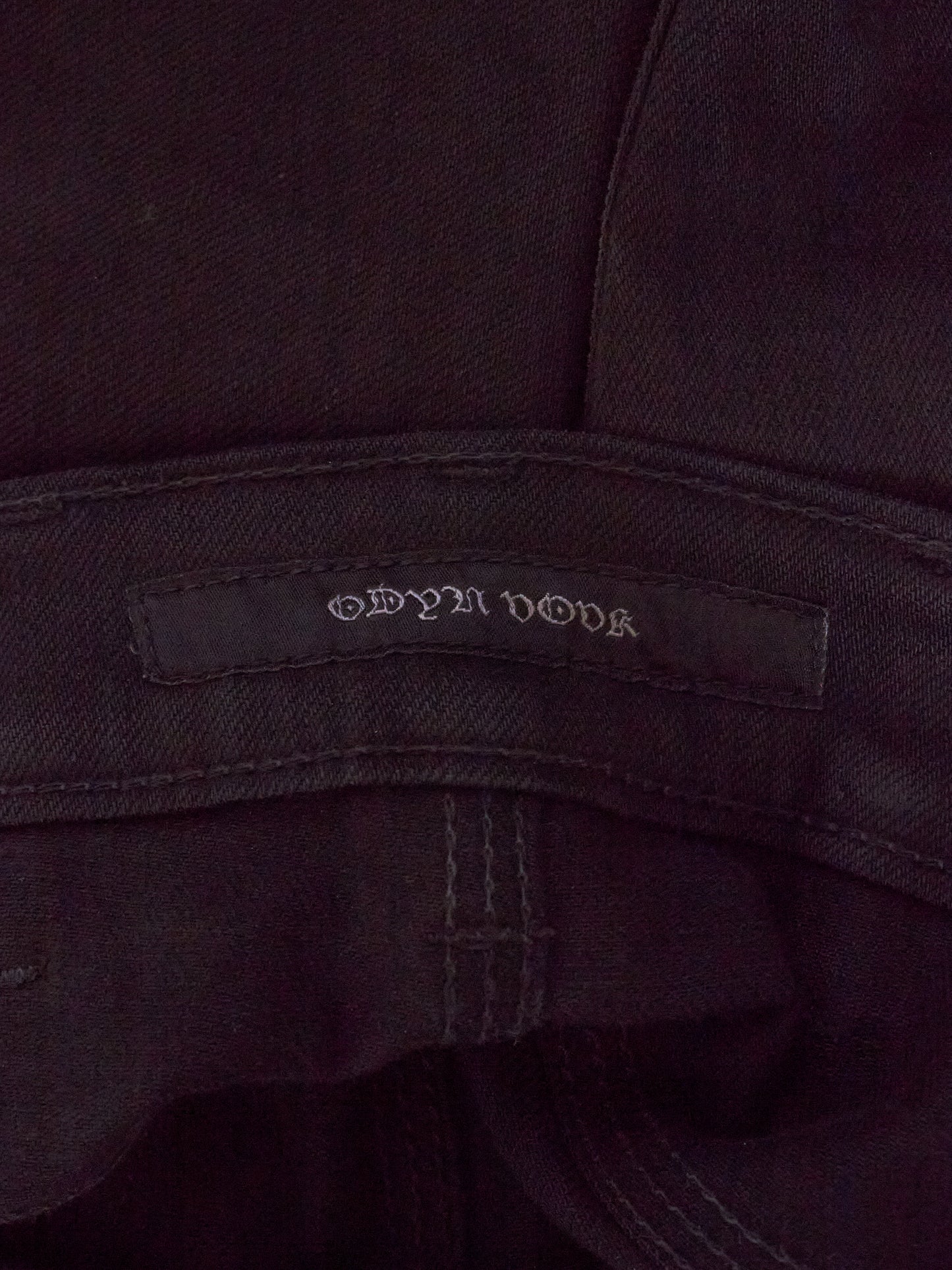 Close-up of a dark fabric with a brand label on a dark background
