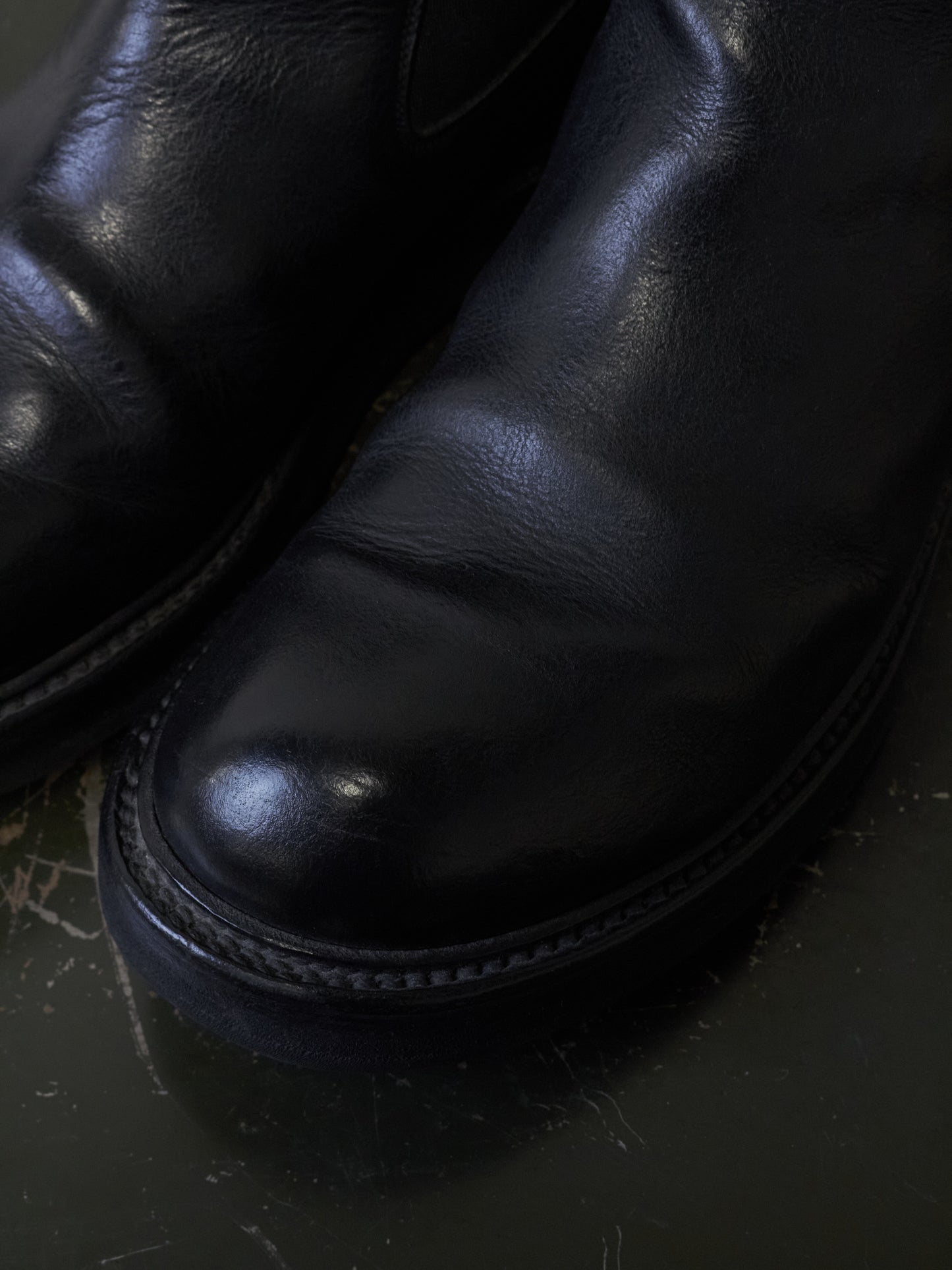 Close-up of black leather shoes on a dark surface