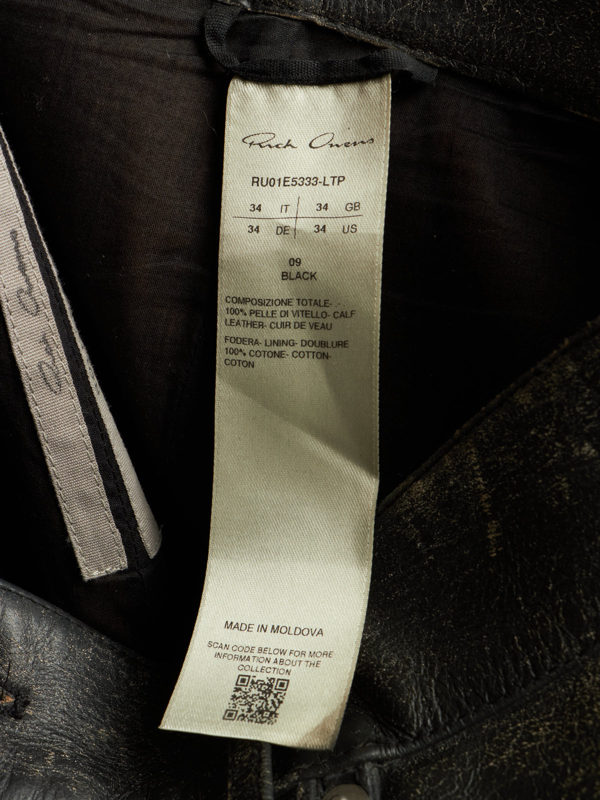 A close-up of a garment's interior label reading 'French Crown' and 'RU01E5333-LTP', with size information and a QR code on a dark fabric background.