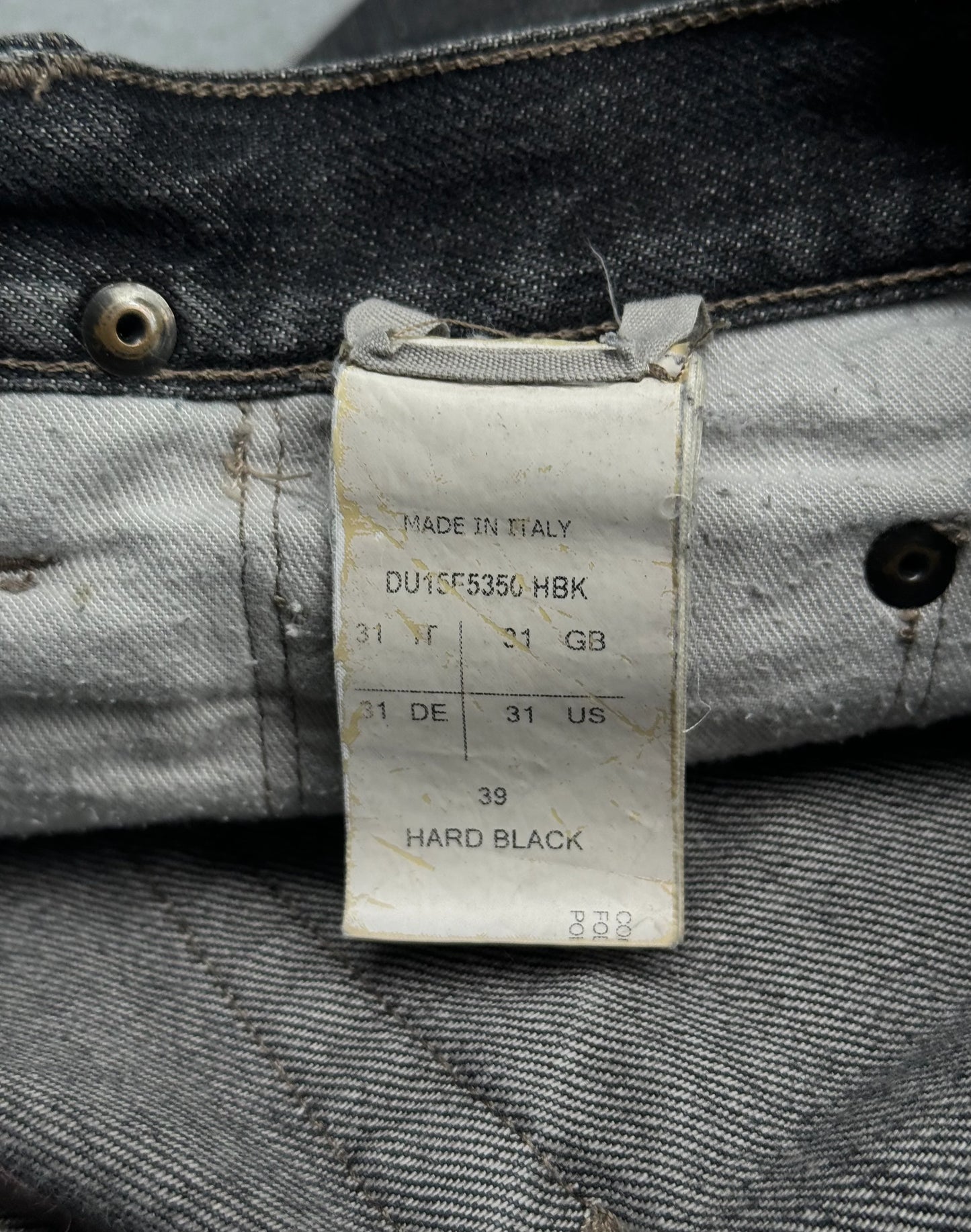 Denim fabric with a label indicating 'Made in Italy' and garment size details.