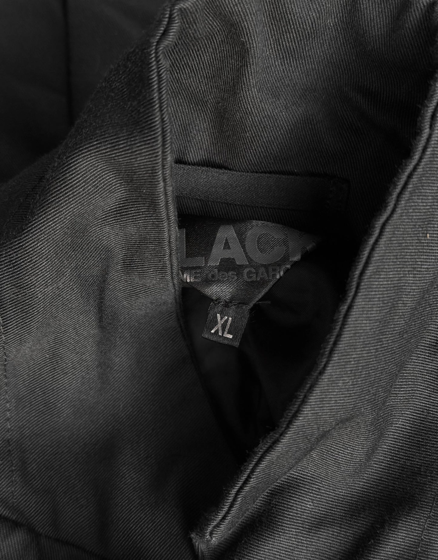Close-up of a black jacket with a visible label inside