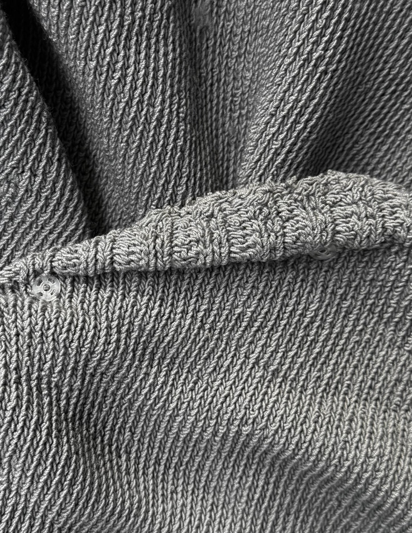 Close-up of gray textured fabric with a button