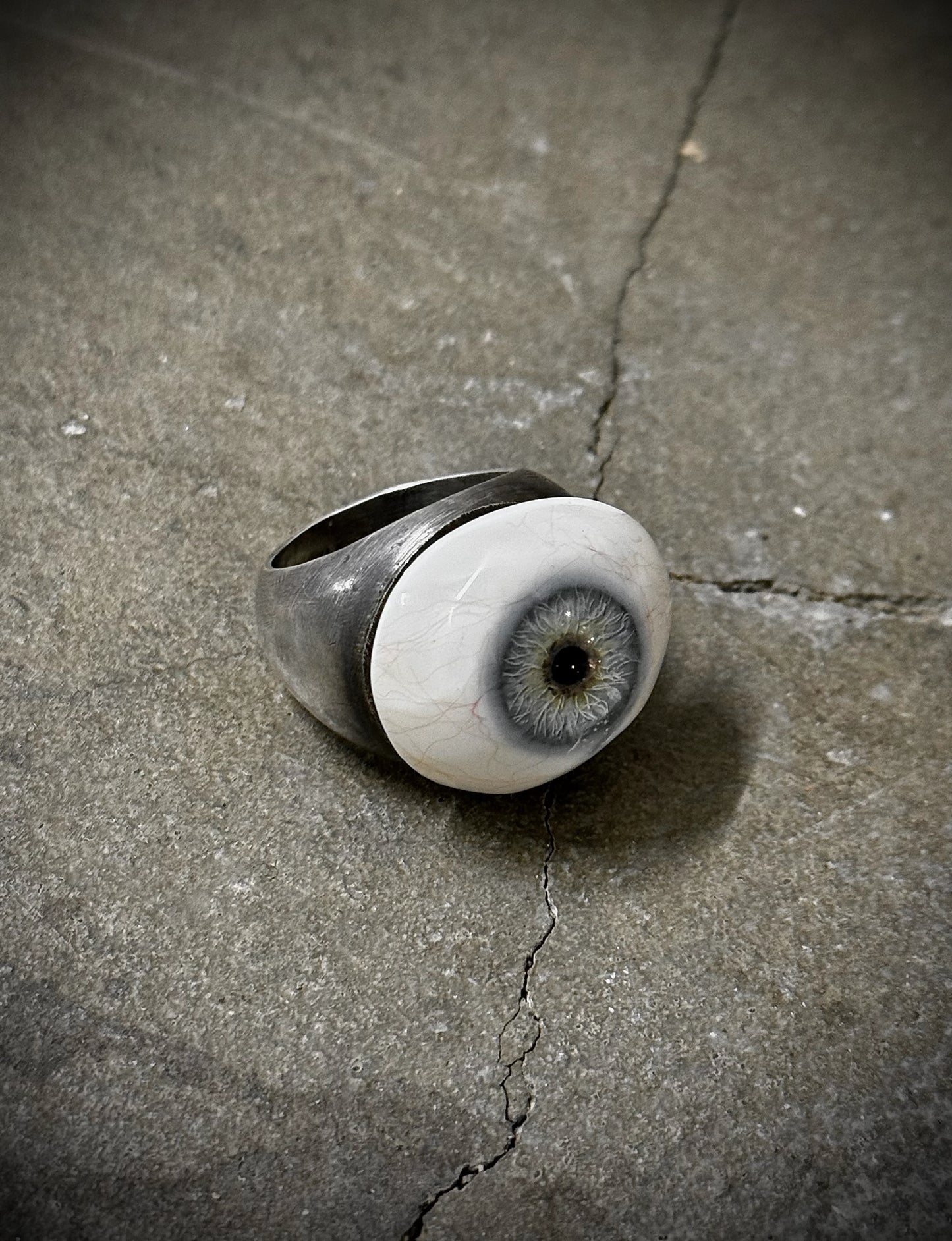 Ring with eye design on a concrete surface