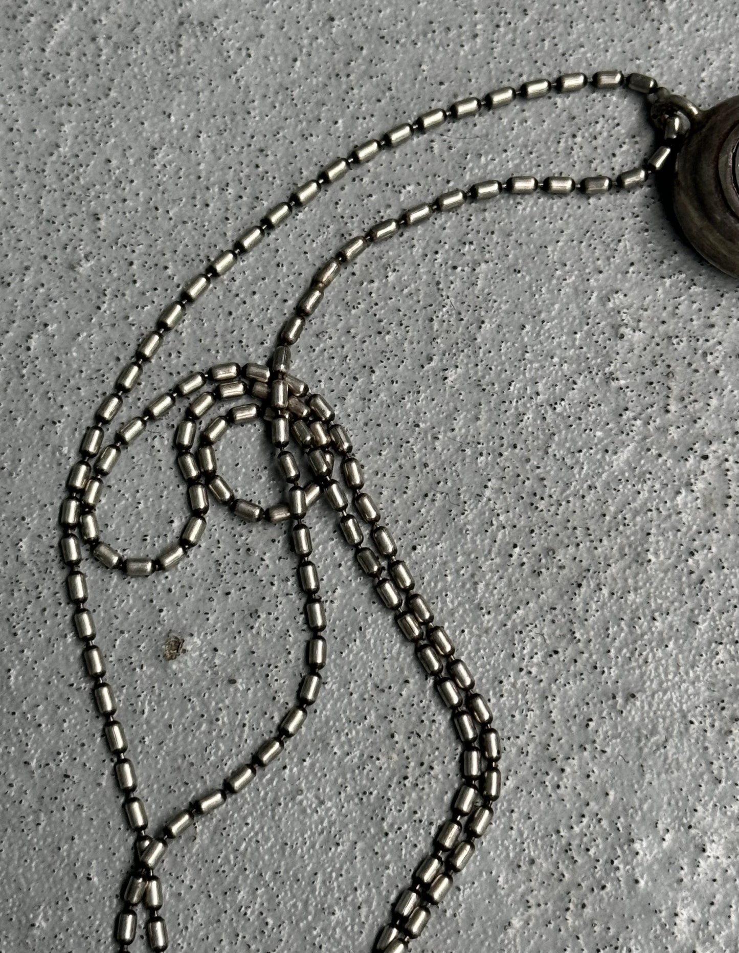 Close-up of a necklace with beads on a textured surface