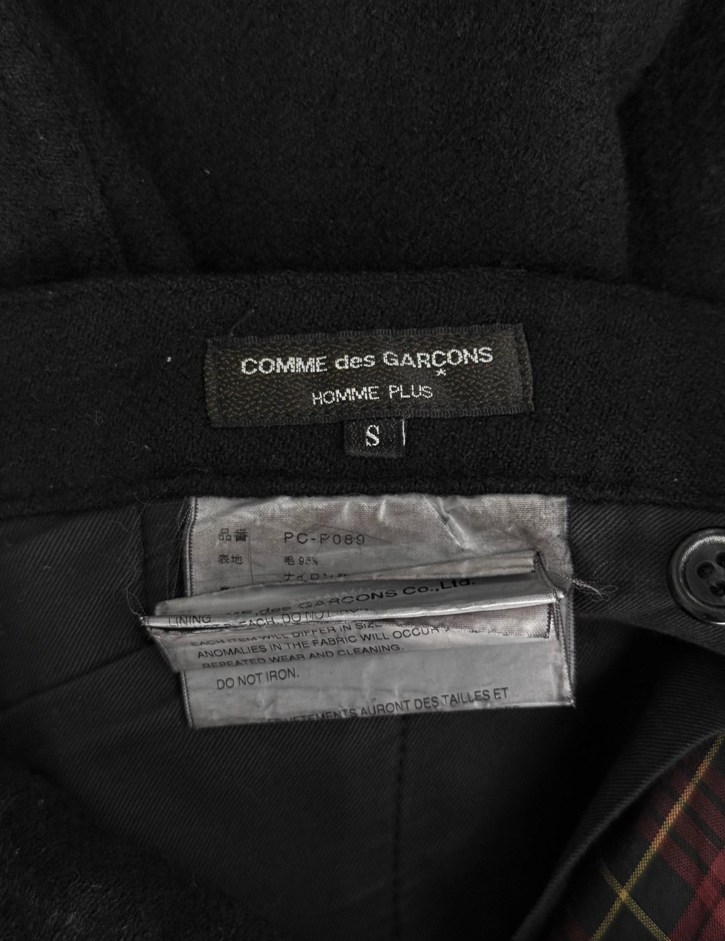 Black garment with Comme des Garcons label and care tag.