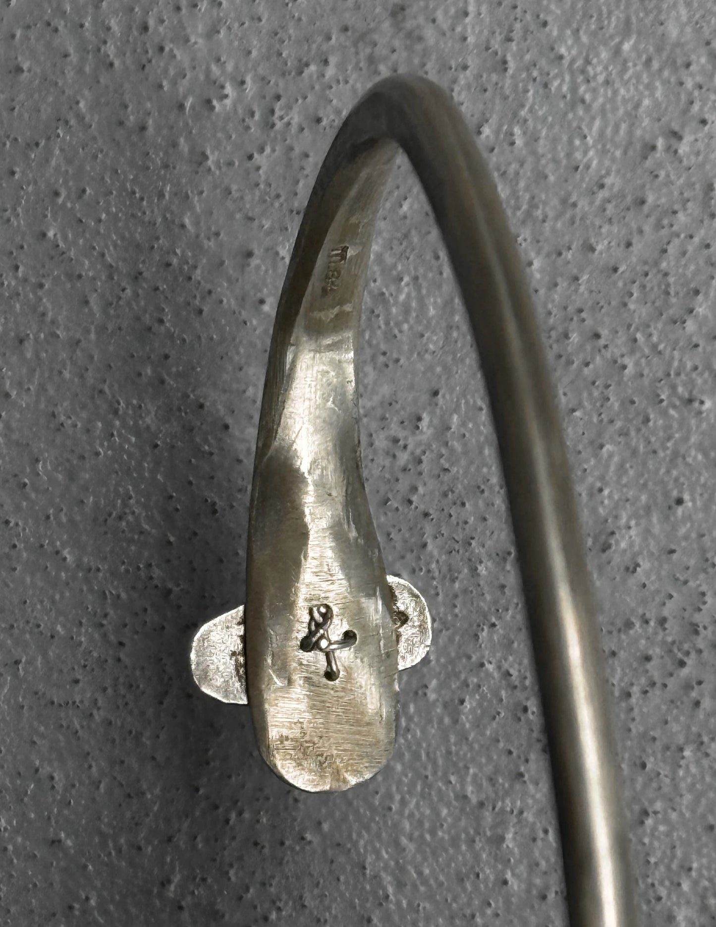 Silver bracelet with engraved design on a gray background