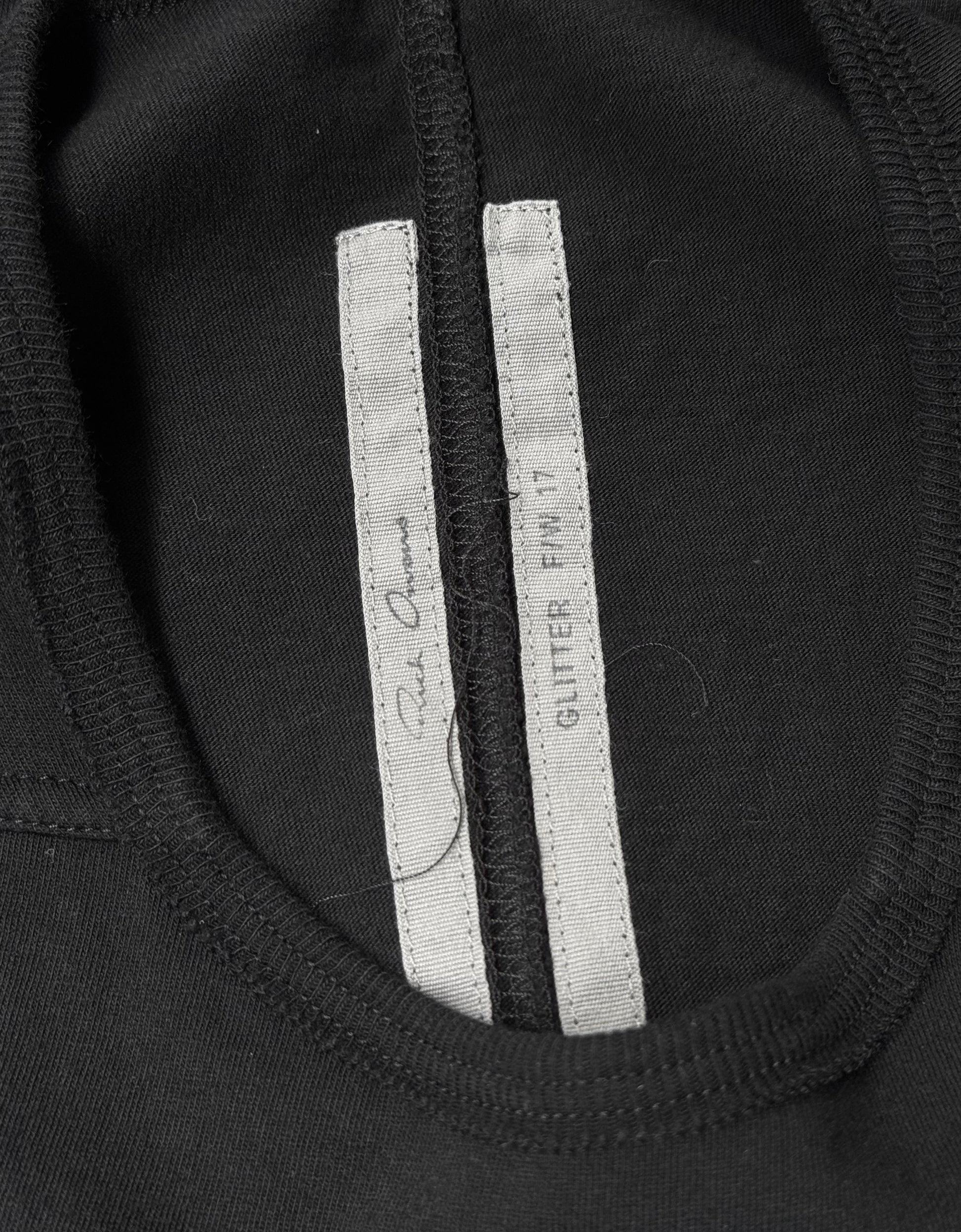 Close-up of a black Rick Owens AW17 “GLITTER” Level Short-sleeves T-shirt collar with two white inner tags—one reading GLITTER FW17 and the other with signature text. Size IT 40, flawless condition.