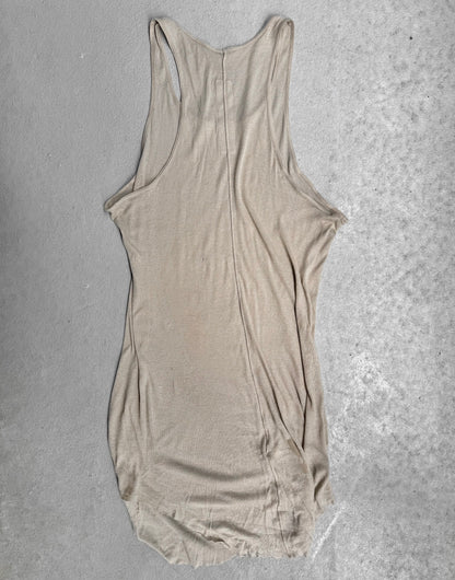 The Rick Owens SS24 “LIDO” Pearl Sheer D-Flap Tank Top, featuring a racerback and sculptural silhouette, is displayed flat on a light gray concrete surface. The fabric is slightly wrinkled with uneven edges.