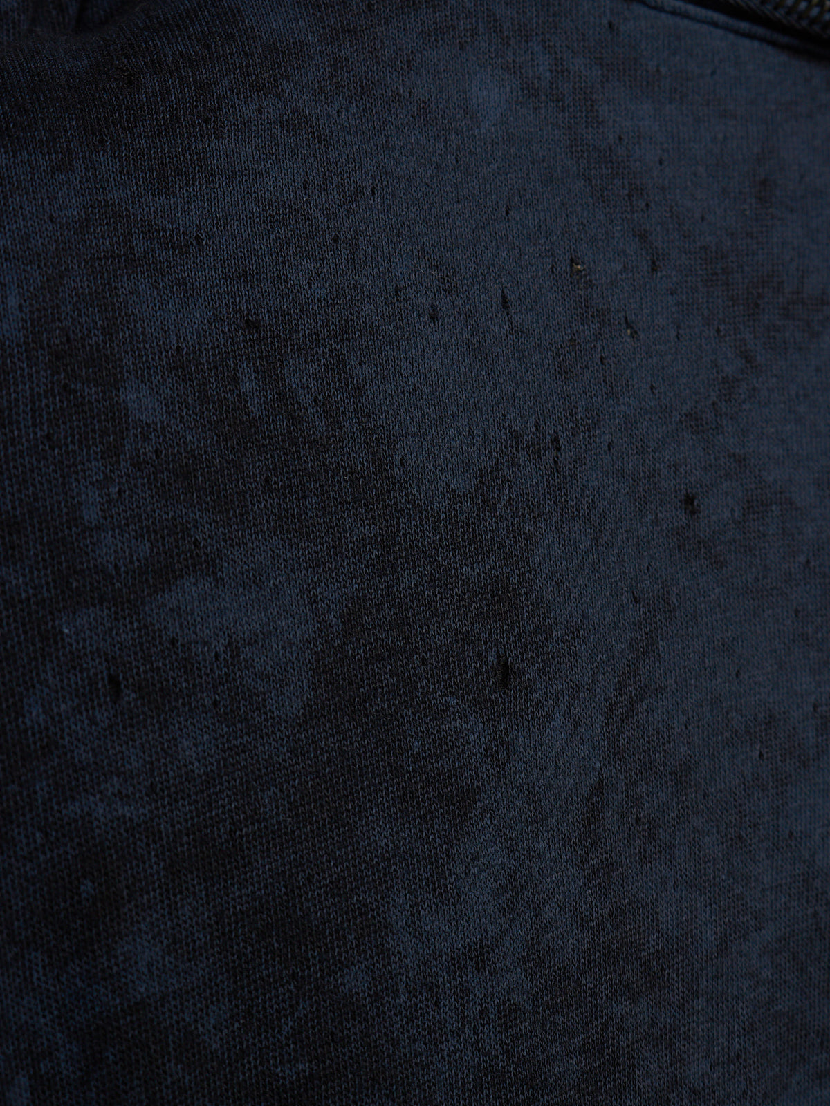 A close-up of a dark navy blue textured fabric surface with a subtle mottled or distressed pattern.