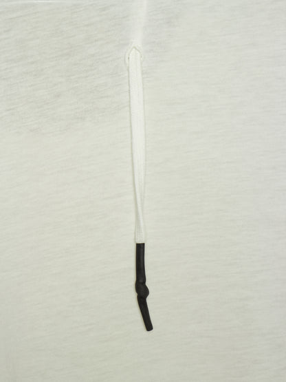 A close-up of a white textured fabric surface with a vertical white drawstring or cord running down the center, ending in a black knotted section near the bottom.