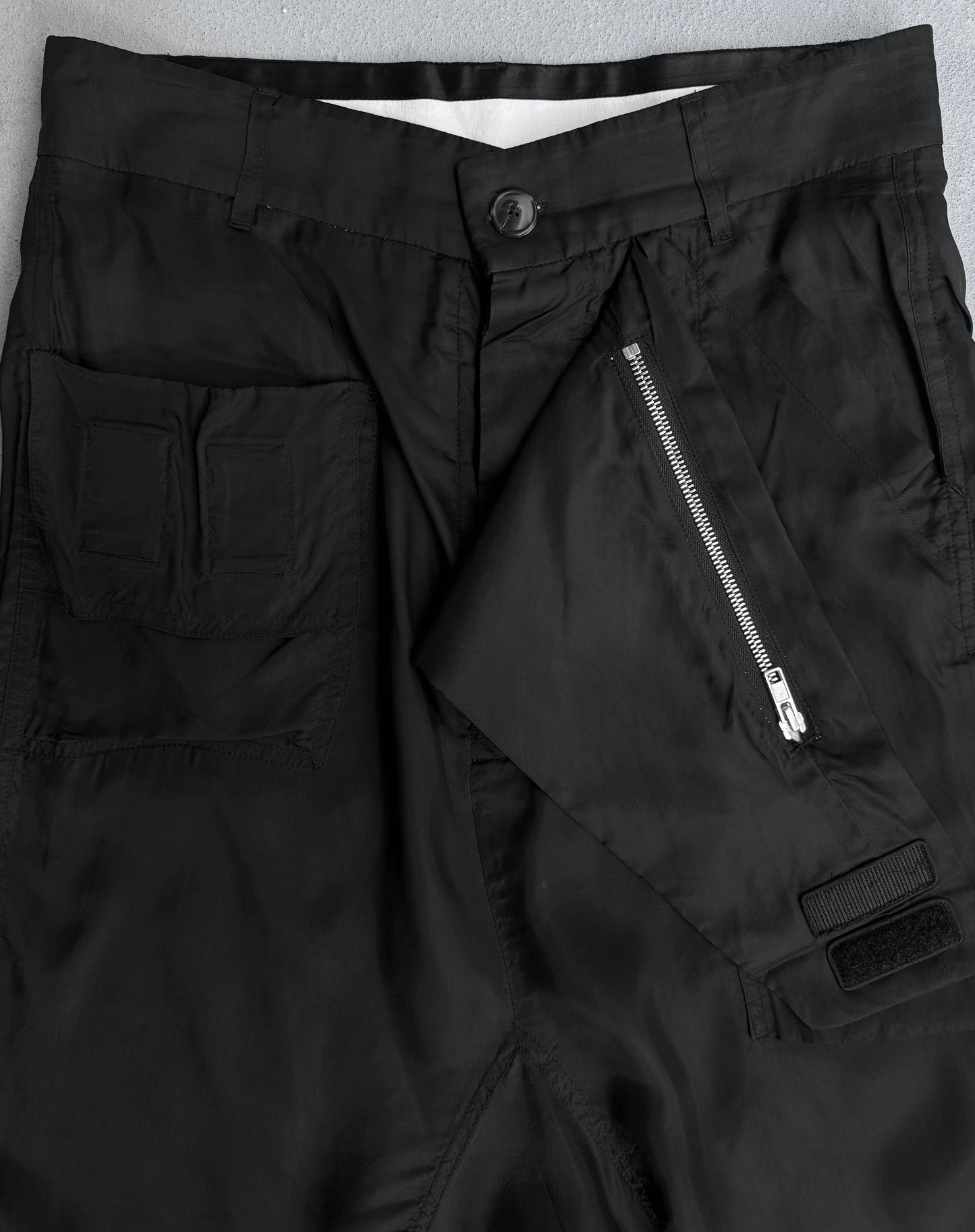 Close-up of Rick Owens SS14 “VICIOUS” Lightweight Memphis Shorts in black, size US 28-29 (IT40), featuring a front zipper partially open, buttoned waistband, and left pocket with two stitched sections. Fabric is lightweight and smooth.
