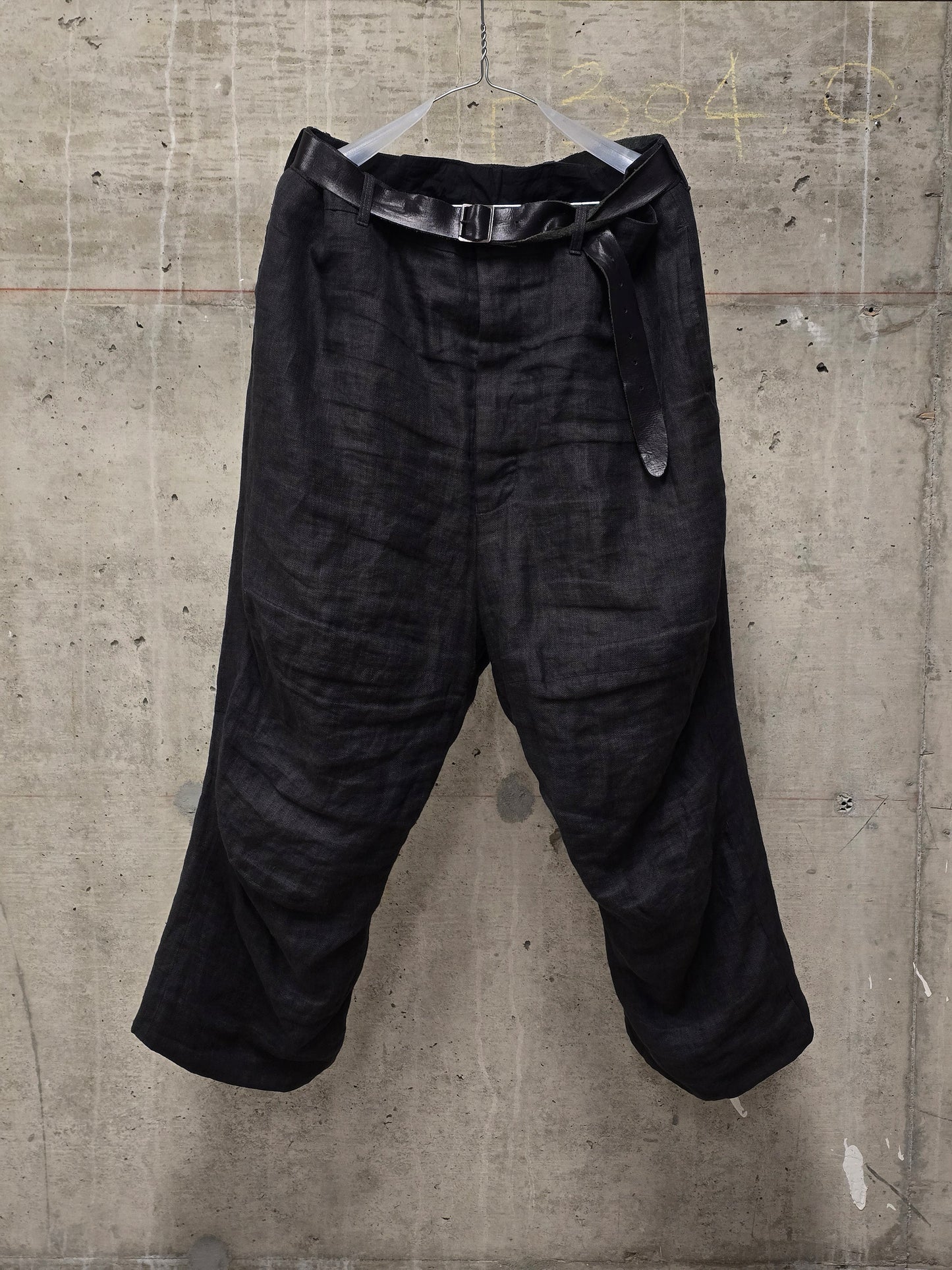 Black pants hanging on a concrete wall