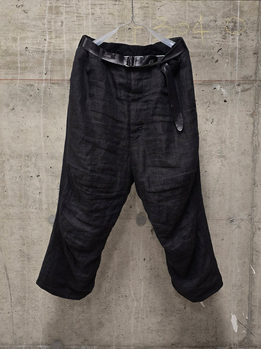 Black pants hanging on a concrete wall