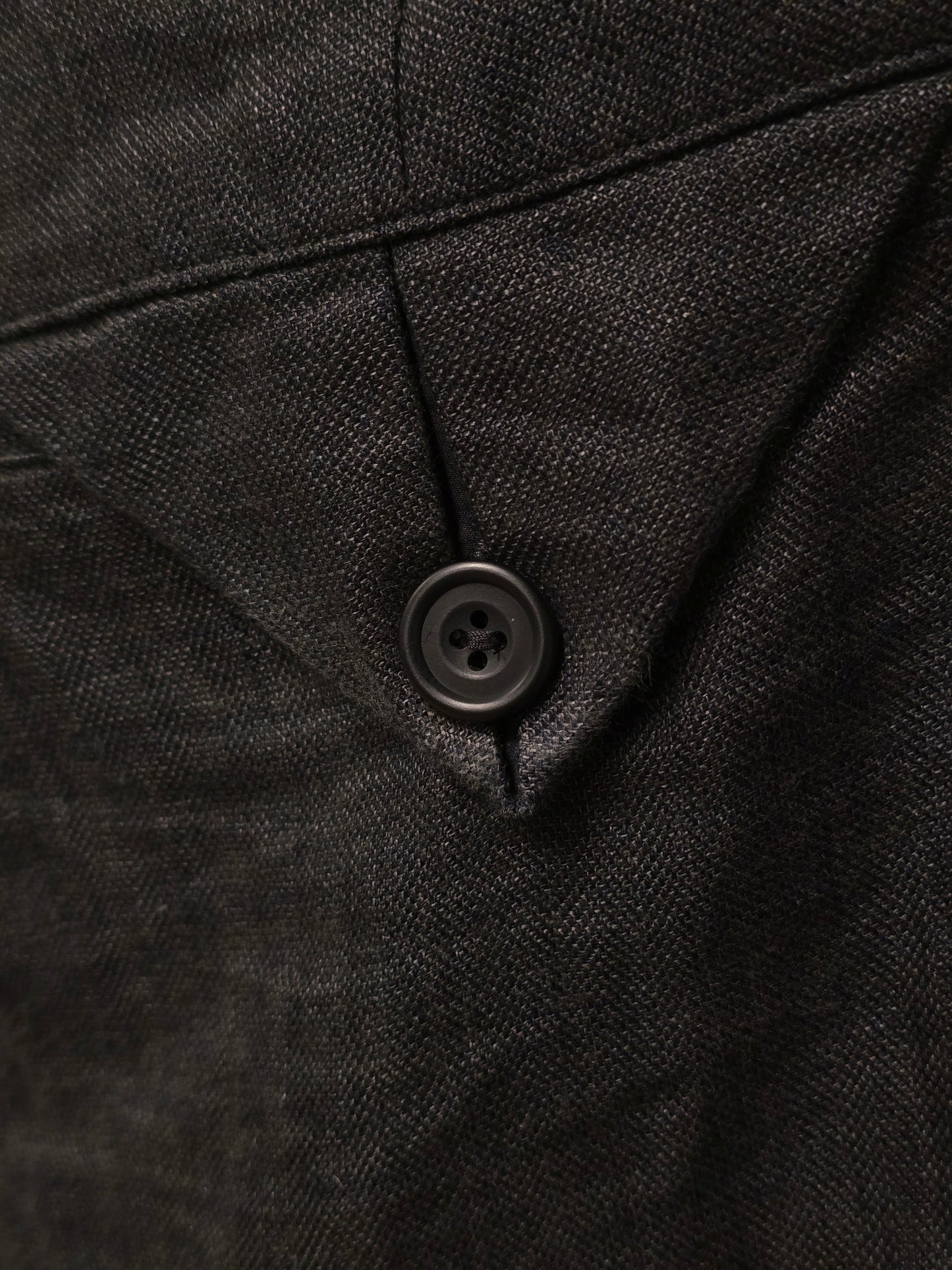 Close-up of a black textured fabric with a button
