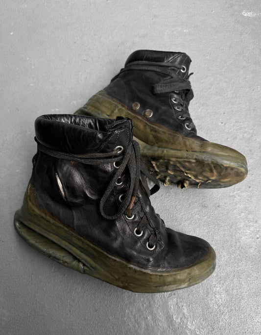A pair of DRIEW Carol Christian Poell ‘AM/2685P ROOMS-PTC/12’ black high-top kangaroo leather sneakers (Size 6, EU 41.5-42) with thick translucent green soles, light wear, scuffs, creases, and loosely tied black laces rest on a gray surface.