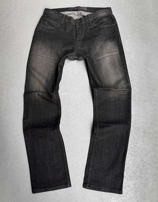 The Surface To Air SS14 Faded Black Bootcut Skinny Denim by Surface To Air lays flat, legs extended and waistband open—a modern staple for contemporary menswear and urban style.