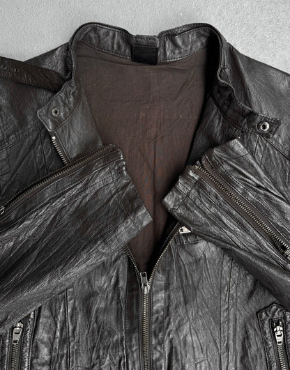 A close-up of the Jackrose Early 00s Multi-pockets Pig Skin Leather Rider Jacket, partly unzipped to reveal its brown lining and folded collar. Signature zippers on sides and sleeves add a biker-inspired Tokyo street style edge.