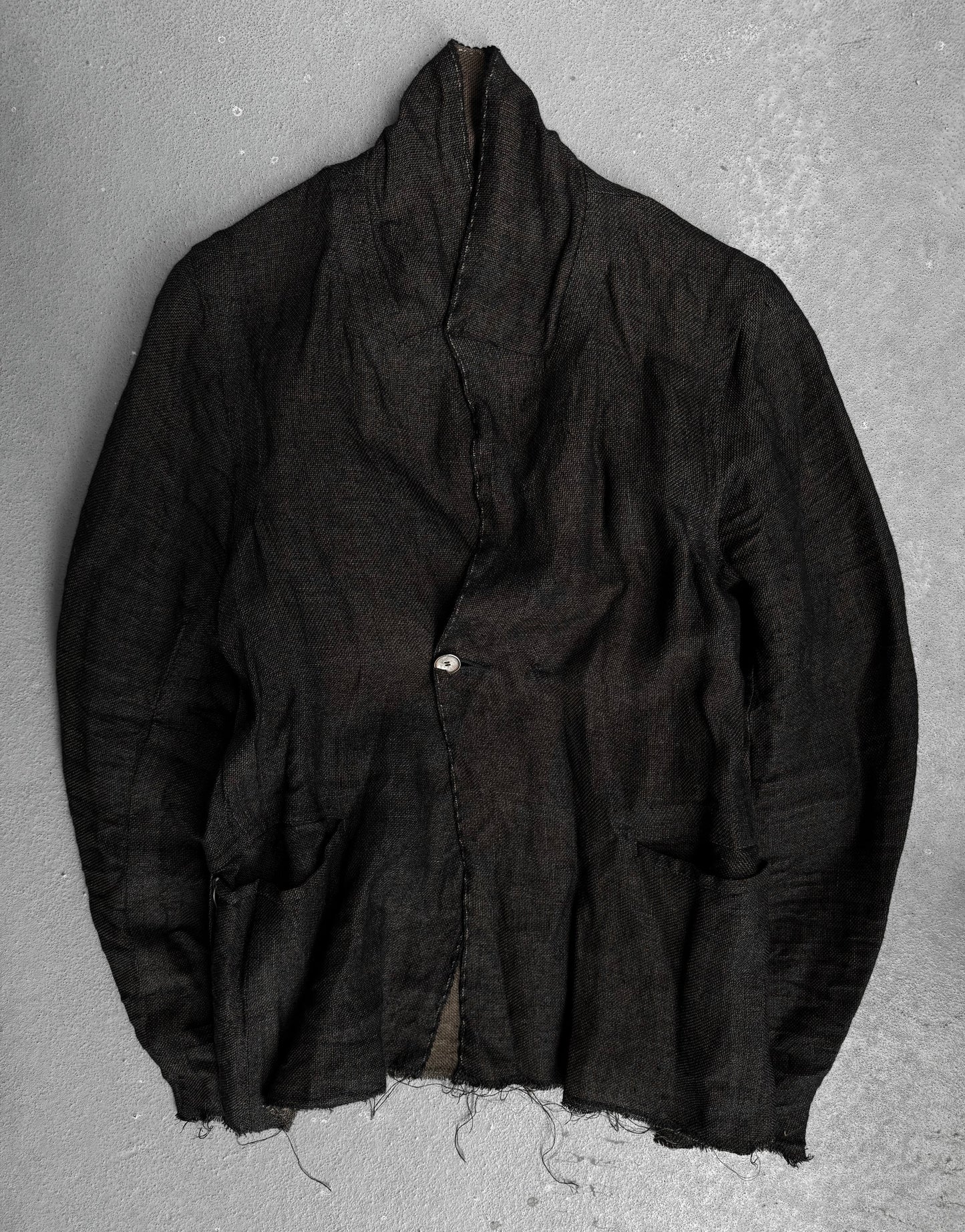 The TaichiMurakami “Coin” Taped Seam Collarless Work Blazer in black Japanese linen features raw, frayed edges, exposed seams, a single fastened button, and two front pockets for an industrial minimalist look.