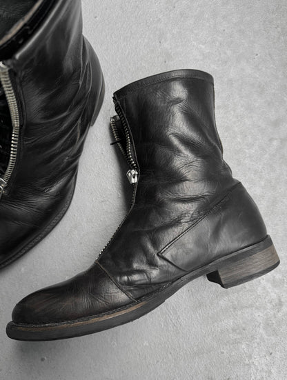 Black leather boots with zippers on a gray surface