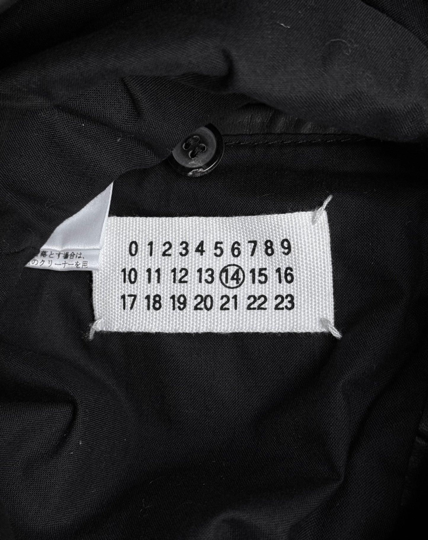 Maison Martin Margiela AW10-11 Kokone Black Horse Leather 5-zip Jacket features a white label with black numbers (0–23), number 14 circled, and a black button above. Size 44 fits like a slim Medium.