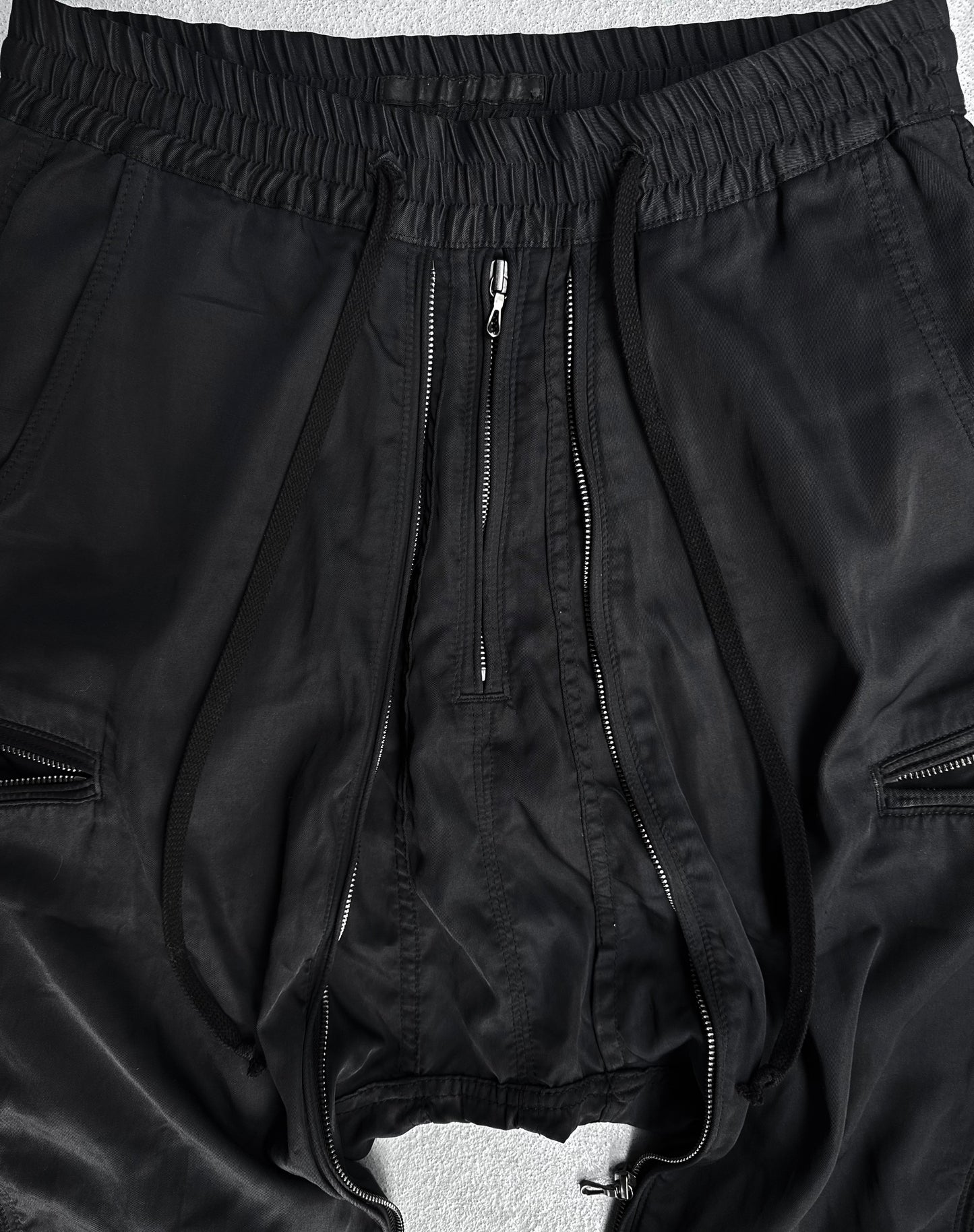 DRIEW Julius_7 SS10 “neurbanvolker;” Convertible Multi-zip Cotton Twill Shorts in flawless condition with low crotch, exposed front zip, drawstrings, elastic waist (fits US 29-32), and side zippers. Displayed on a light surface.