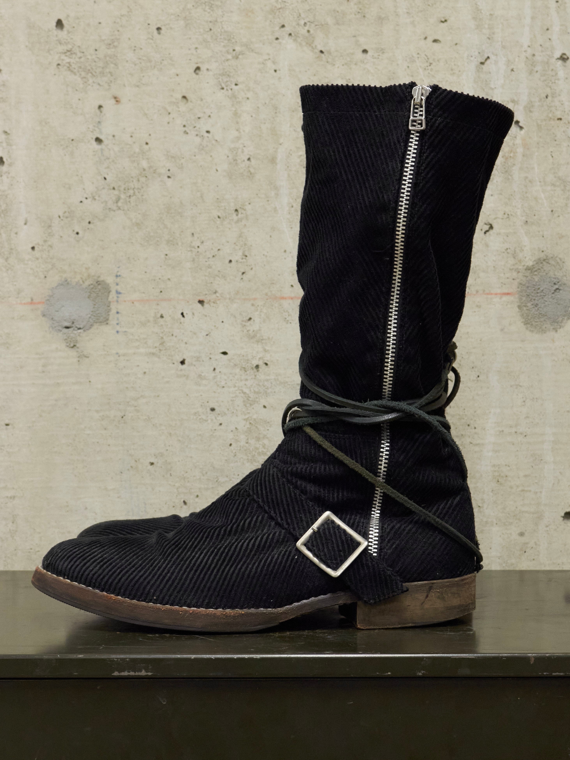 Black boot with a zipper on a textured surface