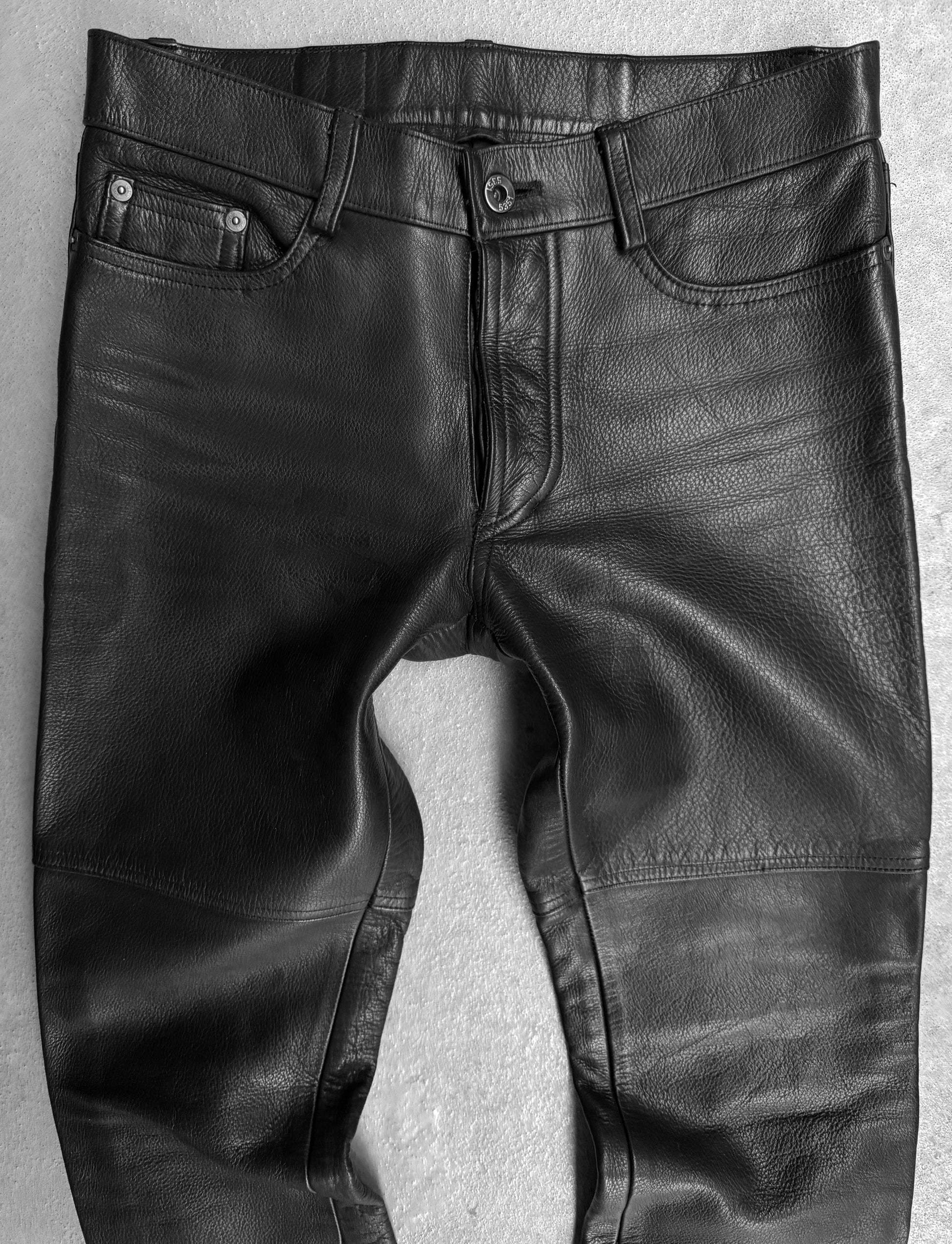 Black leather pants on a textured gray background