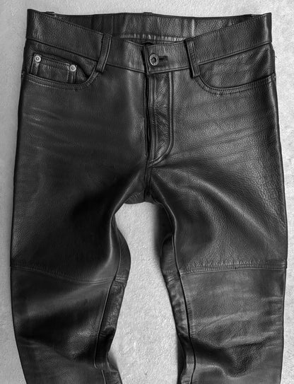 Black leather pants on a textured gray background