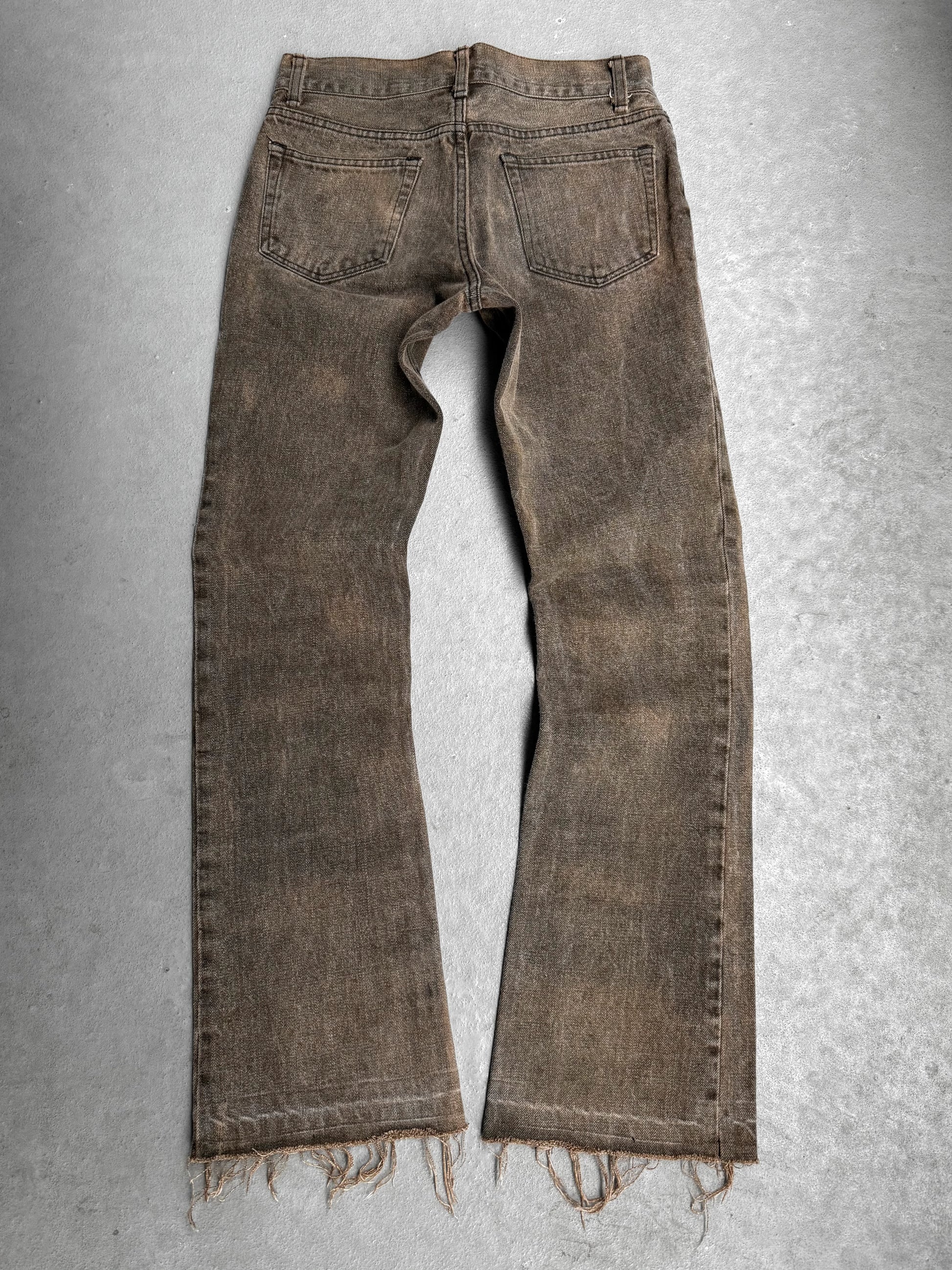 Brown distressed jeans on a gray background