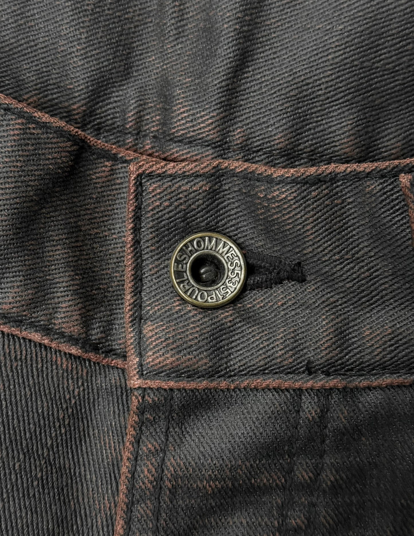 Close-up of a button on a dark denim jacket