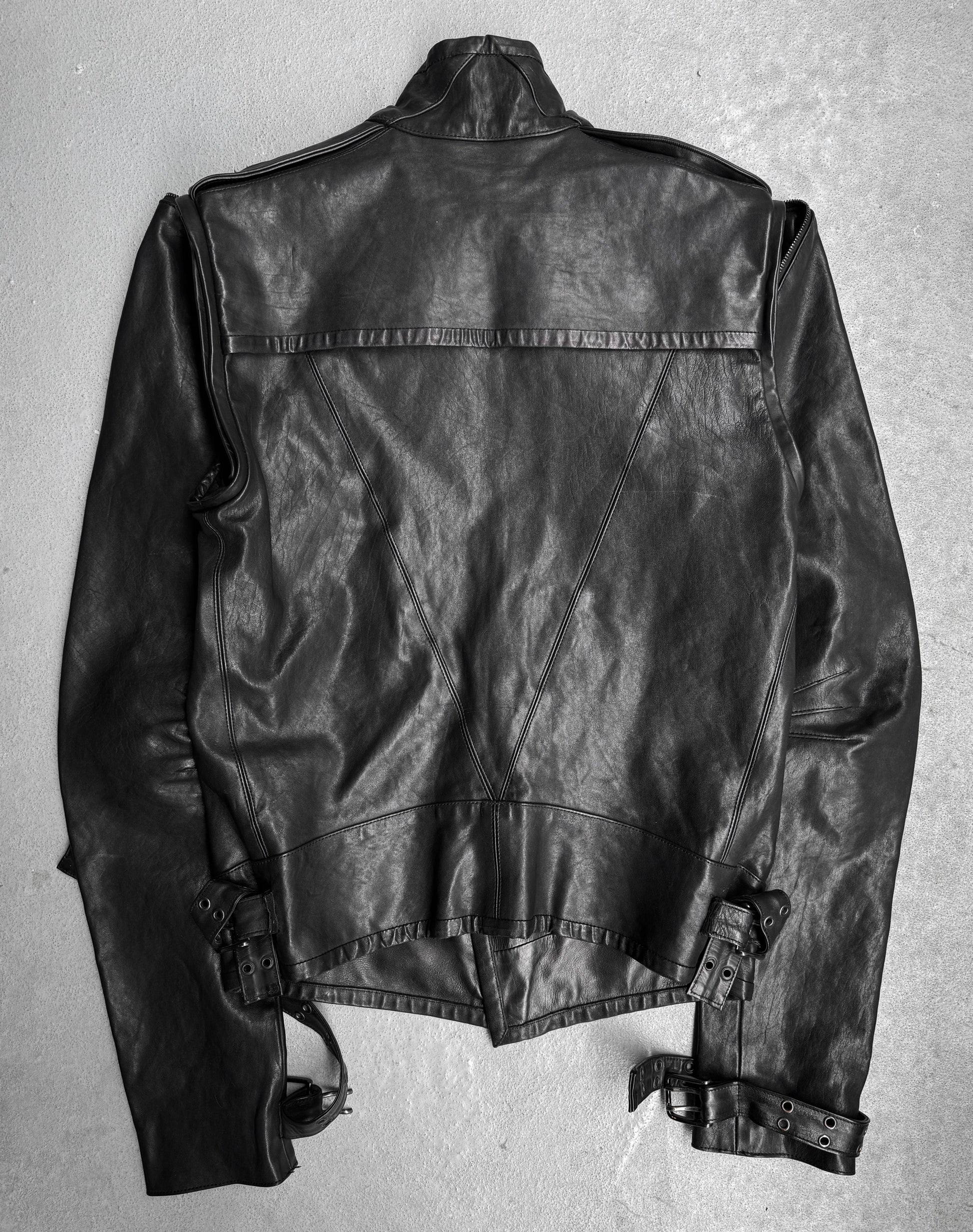 The Gareth Pugh AW09 Detachable Sleeves Horse Leather Riders Jacket is shown laid flat, back view, on a light surface. It features detailed stitching, shoulder epaulets, and adjustable waist and wrist belts—a signature Gareth Pugh design.