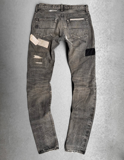 Mihara Yasuhiro AW10 Double-pockets Repair Patchwork Selvedge Denim—gray jeans featuring visible distressing, patch repairs (white striped, black), and frayed hems, ideal for a streetwear-inspired look.