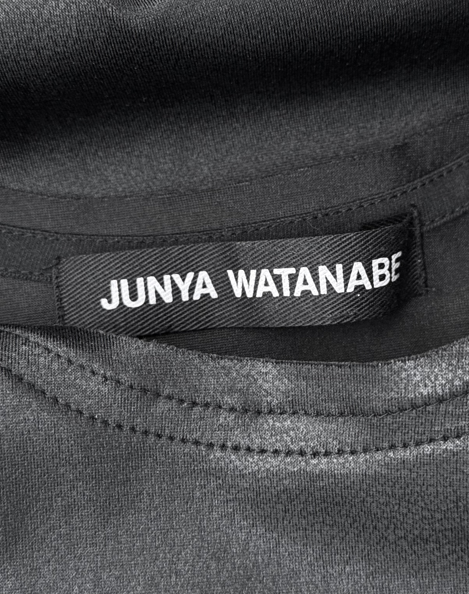 A close-up of a black fabric label with white text reading Junya Watanabe, sewn inside a Junya Watanabe SS23 Waxed Scoop-neck Tank Top, Size S, in flawless condition.