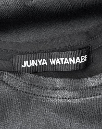A close-up of a black fabric label with white text reading Junya Watanabe, sewn inside a Junya Watanabe SS23 Waxed Scoop-neck Tank Top, Size S, in flawless condition.
