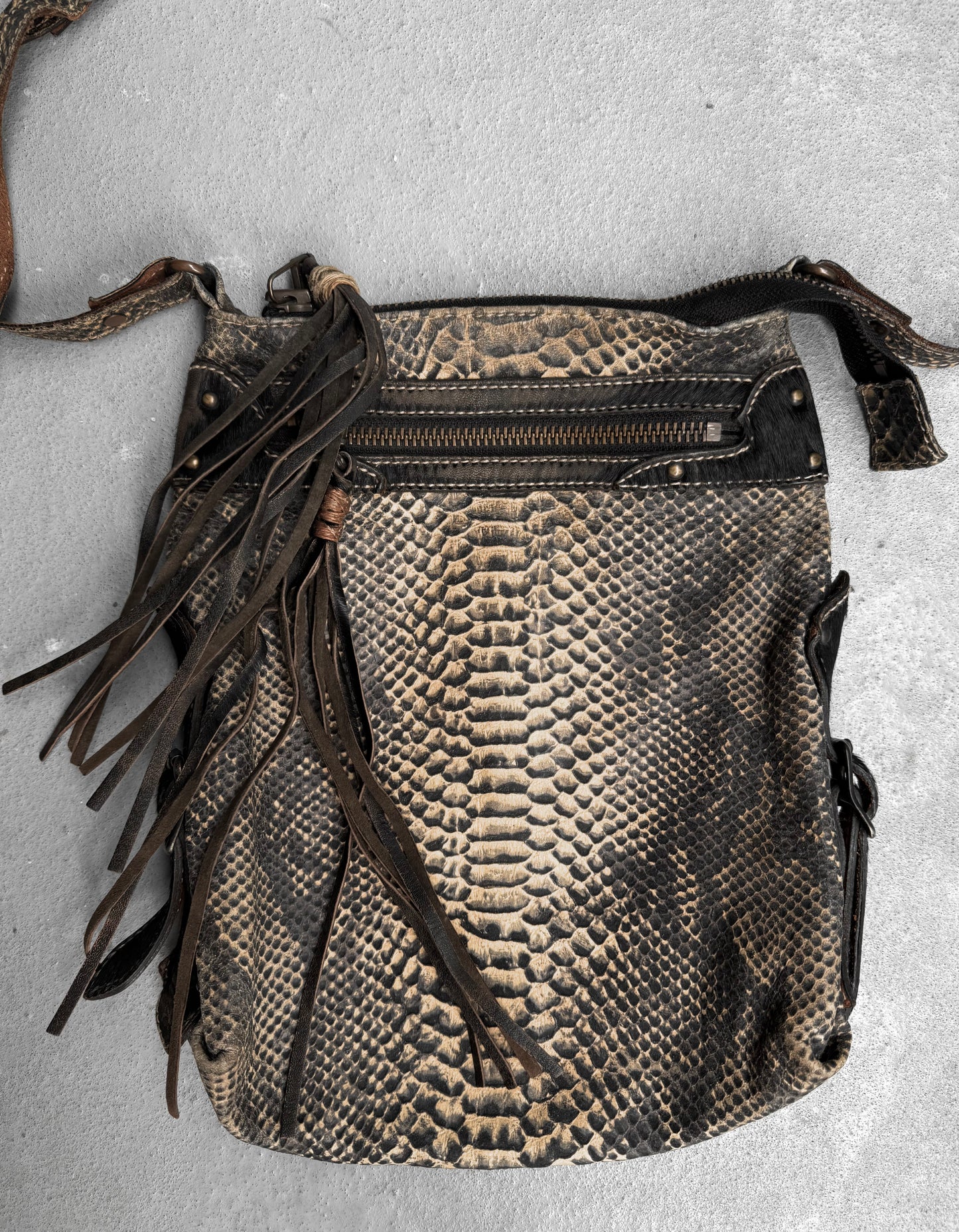 A Kyoji Maruyama Early 00s yellow crocodile embossed leather side bag with a zippered pocket, decorative leather fringe, and long strap is displayed on a gray surface—an elegant piece from the designer brand.