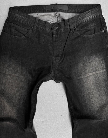 Surface To Air SS14 Faded Black Bootcut Skinny Denim jeans by Surface To Air, featuring a faded black wash, front pockets, belt loops, and button closure. Laid flat on a light surface for a modern urban look.
