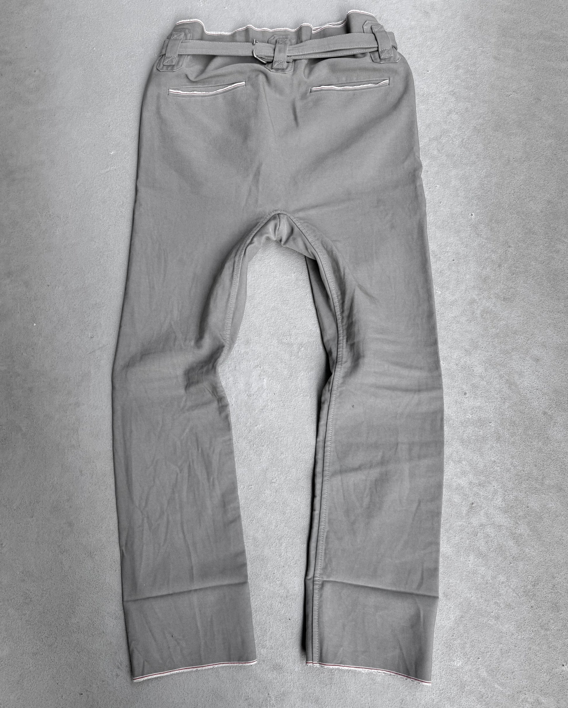 The Carol Christian Poell 2010 “IN-BETWEEN” PM/2578 PEDGE Self-edge High-waisted Metre Pants are shown laid flat on a light gray surface, back view, highlighting the brands avant-garde approach and distinctive material use.