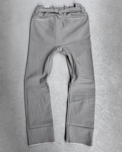 The Carol Christian Poell 2010 “IN-BETWEEN” PM/2578 PEDGE Self-edge High-waisted Metre Pants are shown laid flat on a light gray surface, back view, highlighting the brands avant-garde approach and distinctive material use.